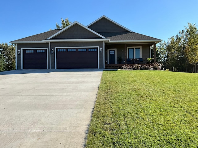 view of front of property featuring a front lawn, a porch, and a garage