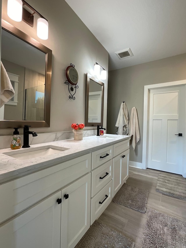 bathroom with walk in shower, wood-type flooring, and vanity