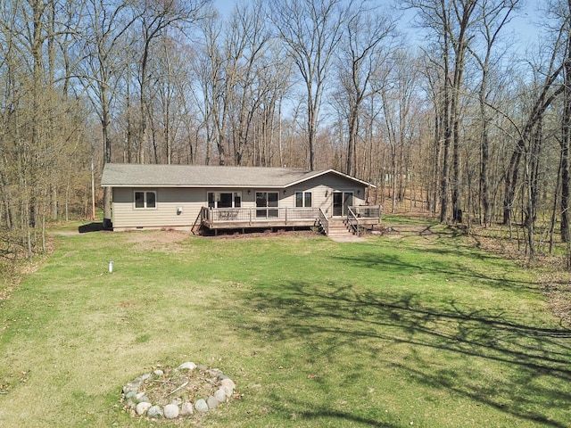 7983 County Road 127, Brainerd, MN 56401 - manufactured / mobile home with a front lawn, a wooden deck, a forest view, and crawl space