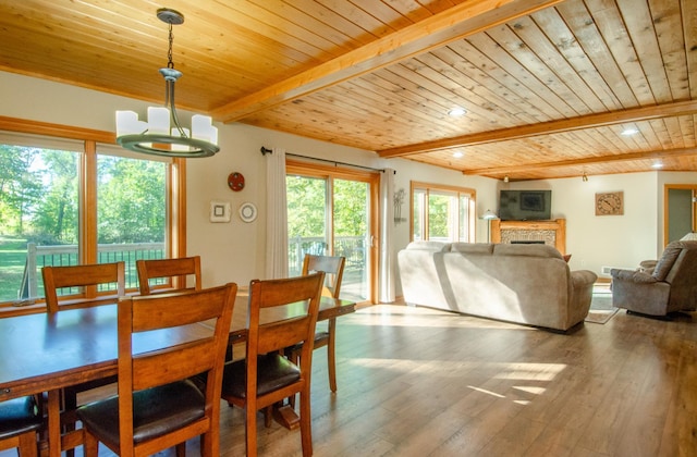 7983 County Road 127, Brainerd, MN 56401 - dining room with wood ceiling, beamed ceiling, a chandelier, wood finished floors, and a fireplace
