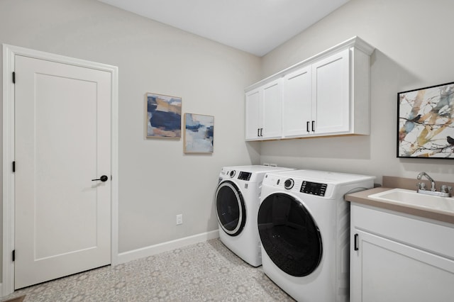 washroom with cabinets, sink, and washing machine and dryer