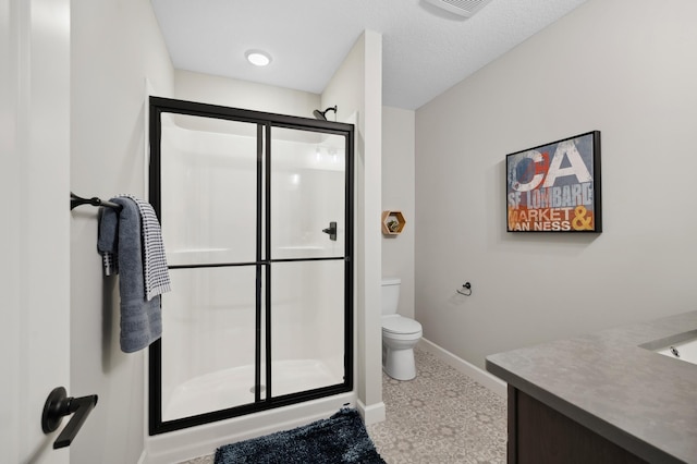 bathroom featuring vanity, a textured ceiling, toilet, and an enclosed shower