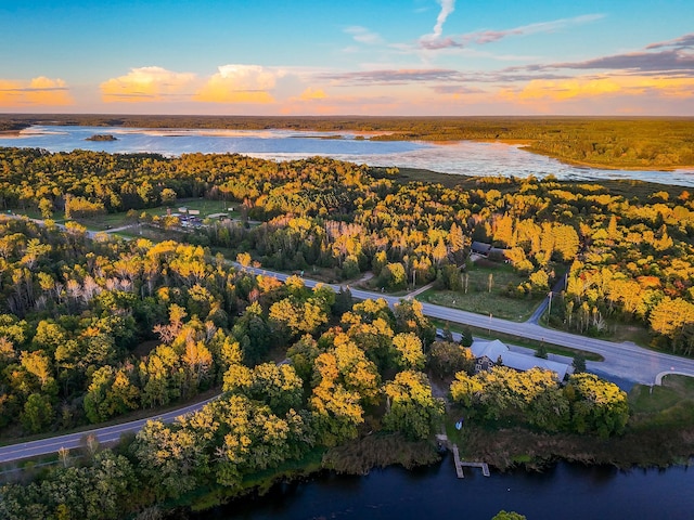 aerial view at dusk featuring a water view