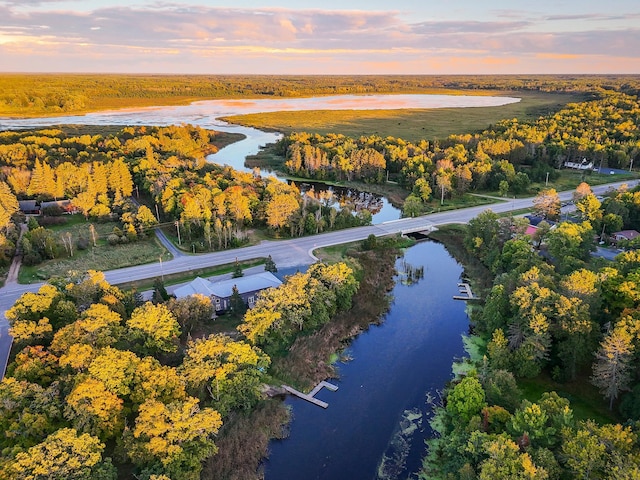 aerial view at dusk featuring a water view