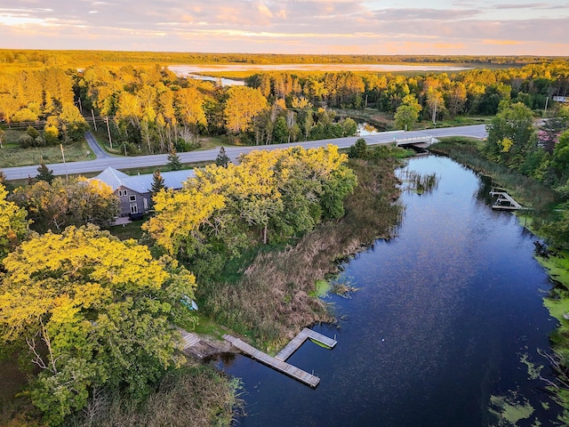 aerial view at dusk featuring a water view