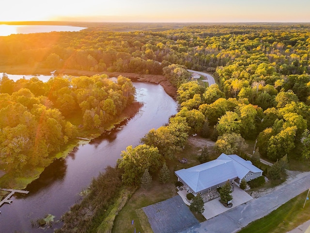 aerial view at dusk featuring a water view