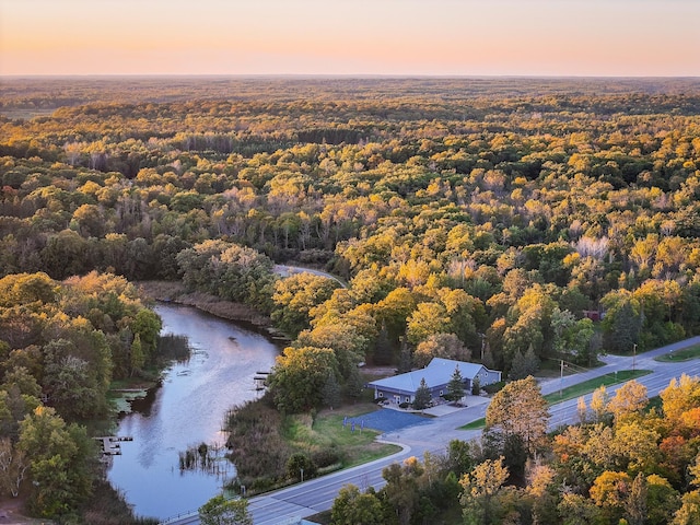 aerial view at dusk featuring a water view