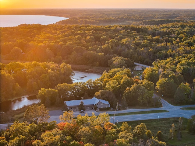 aerial view at dusk featuring a water view