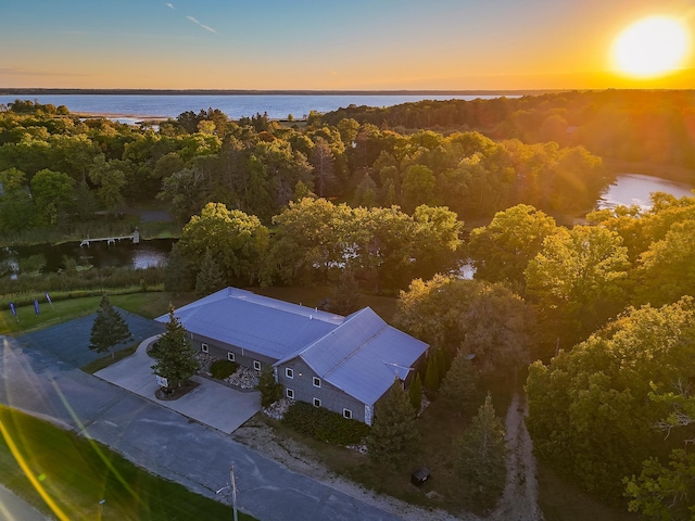 aerial view at dusk featuring a water view