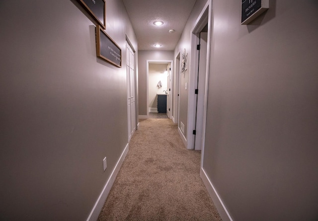 hallway featuring light colored carpet