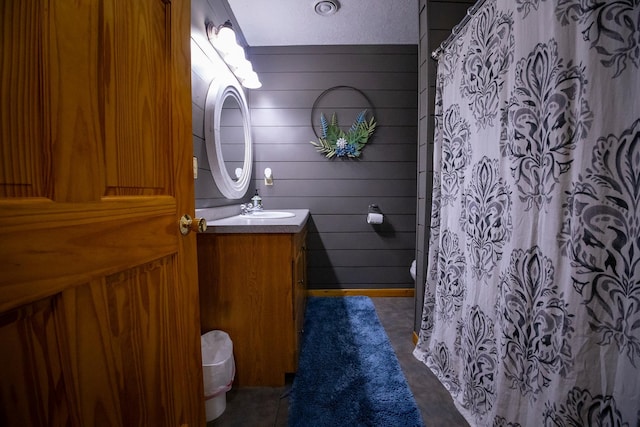 bathroom featuring wood walls, vanity, toilet, and tile patterned floors