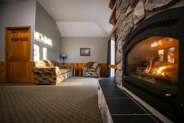 bedroom with a stone fireplace, wooden walls, lofted ceiling, and carpet