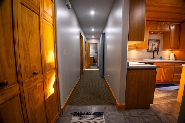 hall featuring sink and dark tile patterned floors