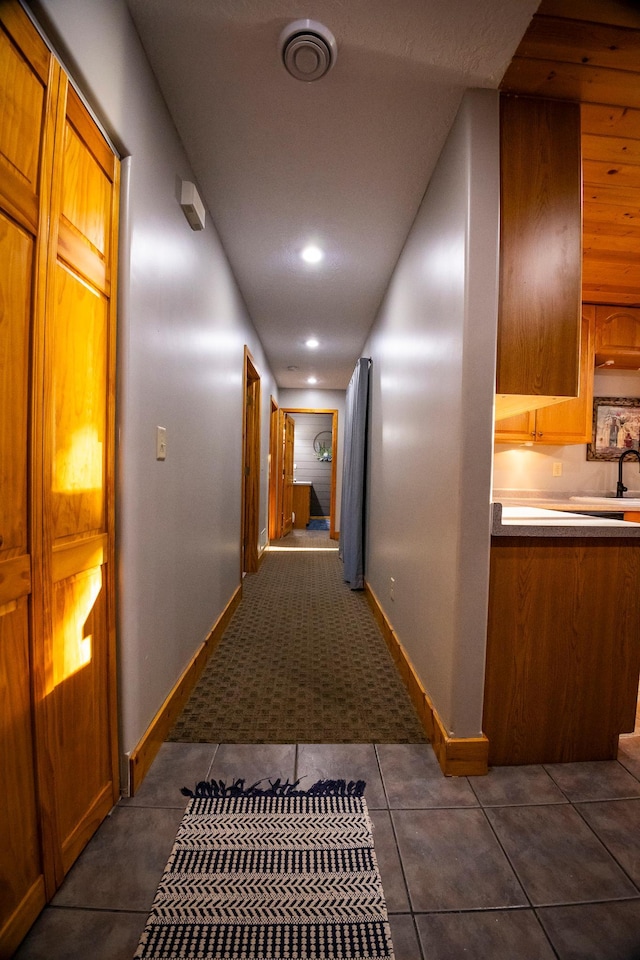 hall featuring dark tile patterned flooring