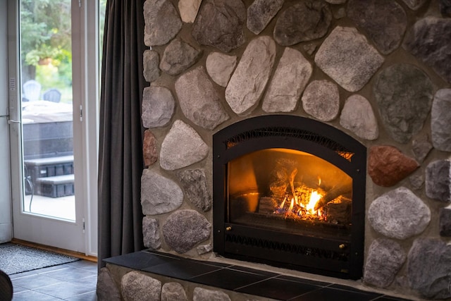 room details with a stone fireplace and tile patterned flooring