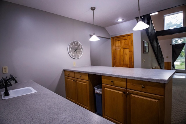 kitchen with carpet floors, lofted ceiling, sink, and decorative light fixtures