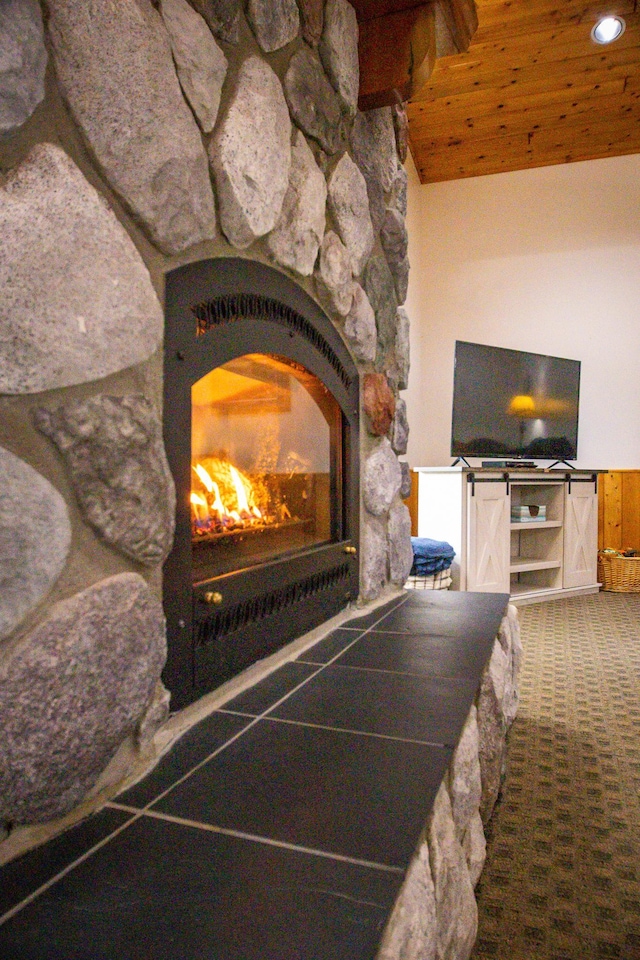 interior details with wood ceiling, carpet, and a fireplace