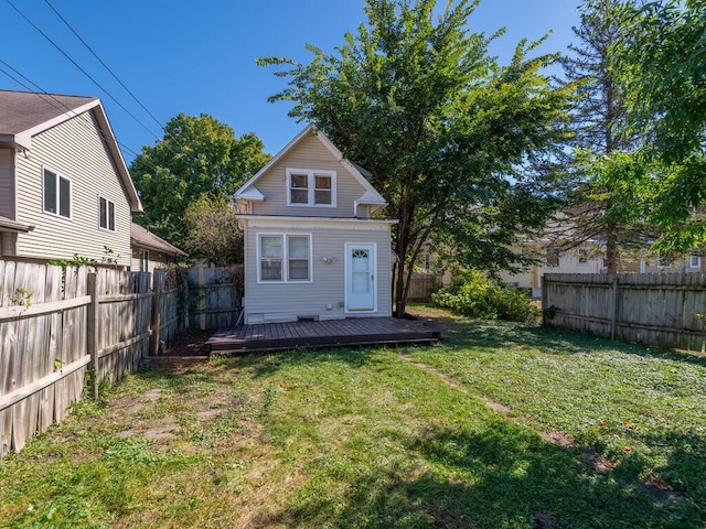 back of property with a lawn and a deck