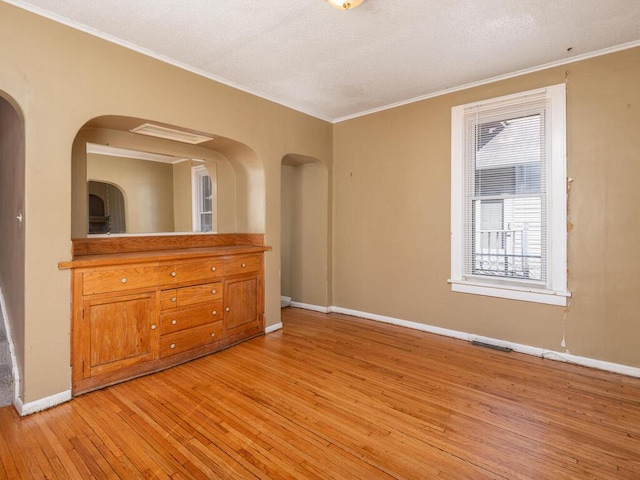 unfurnished room featuring light wood-type flooring and ornamental molding