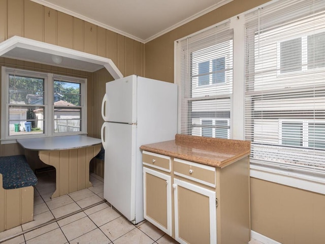 kitchen with white fridge, crown molding, and light tile patterned flooring