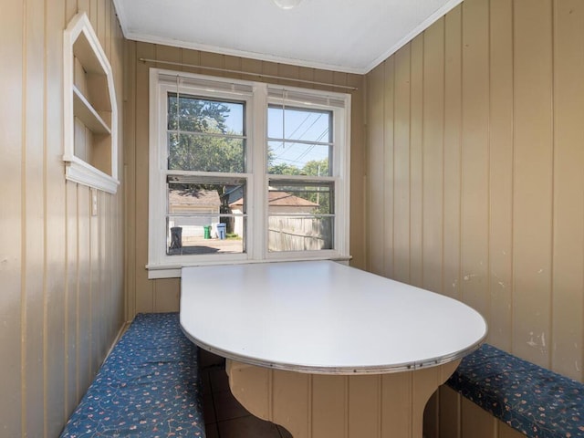 misc room featuring wood walls and ornamental molding