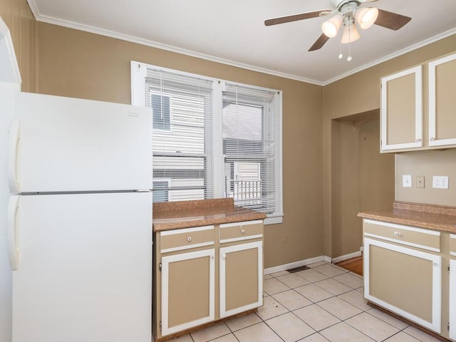 kitchen featuring light tile patterned floors, white refrigerator, ceiling fan, and ornamental molding