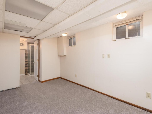 basement featuring light colored carpet and a drop ceiling