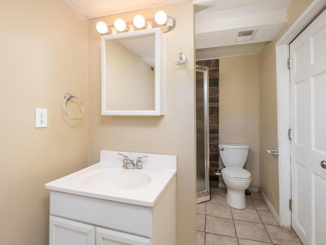 bathroom featuring tile patterned flooring, vanity, an enclosed shower, and toilet