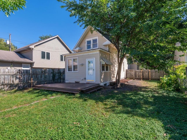 rear view of house featuring a lawn and a deck