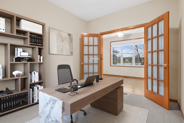 home office featuring light colored carpet, a textured ceiling, and french doors