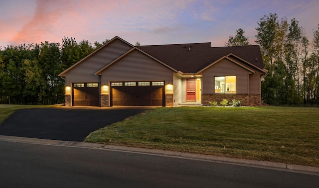 view of front facade with aphalt driveway, a front yard, and a garage