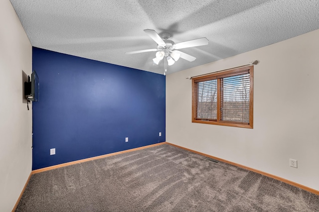 empty room with baseboards, visible vents, ceiling fan, a textured ceiling, and carpet floors