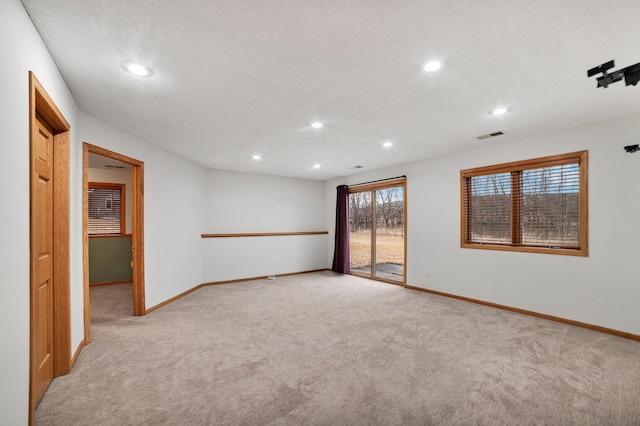 unfurnished room featuring recessed lighting, light colored carpet, visible vents, and baseboards