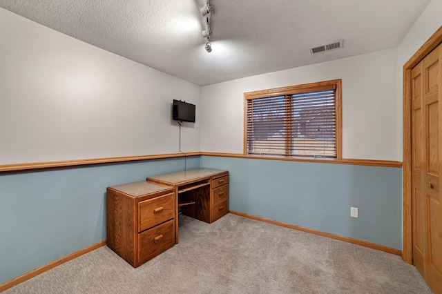 home office featuring visible vents, baseboards, rail lighting, a textured ceiling, and carpet floors