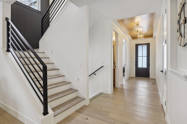 foyer with light wood-type flooring, wooden ceiling, and a wealth of natural light