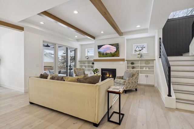 living room with light wood-type flooring and beam ceiling