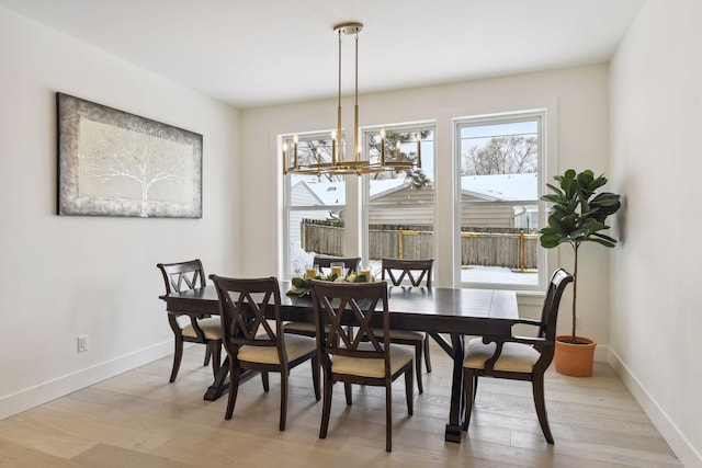 dining area featuring light wood-type flooring and a chandelier