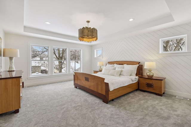 carpeted bedroom featuring a raised ceiling