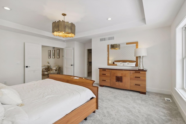 carpeted bedroom with a raised ceiling, a chandelier, and multiple windows