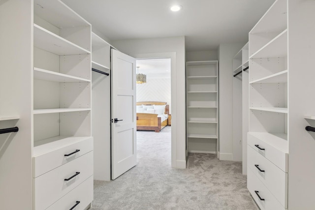 walk in closet featuring light carpet