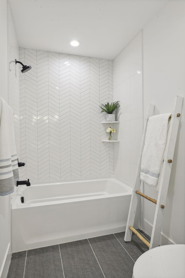 bathroom with tiled shower / bath, toilet, and tile patterned floors