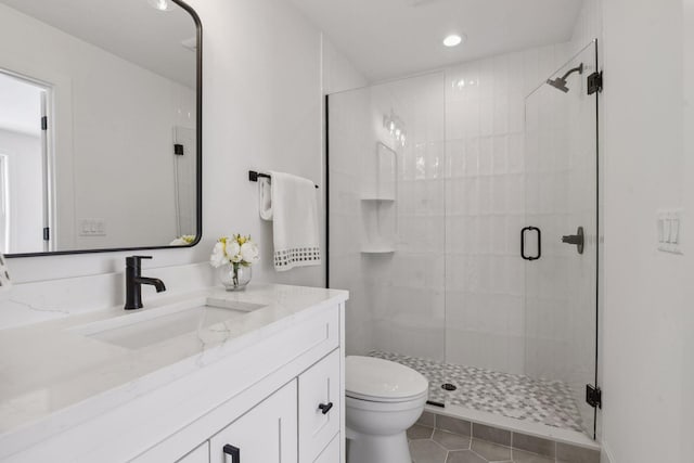 bathroom featuring vanity, a shower with shower door, toilet, and tile patterned flooring