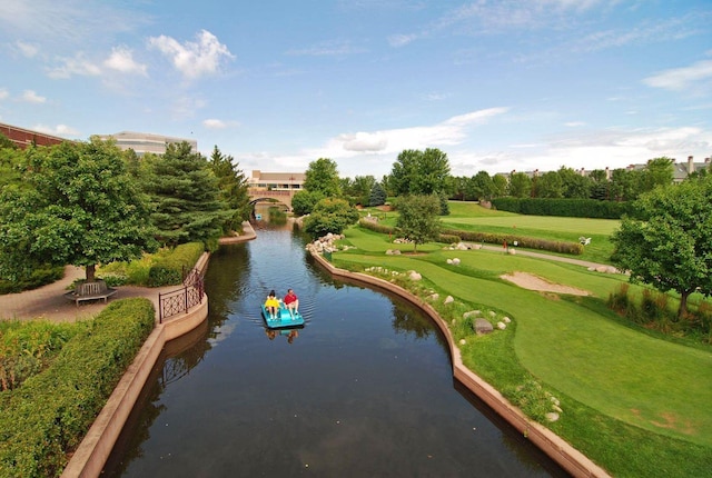 view of property's community with a lawn and a water view