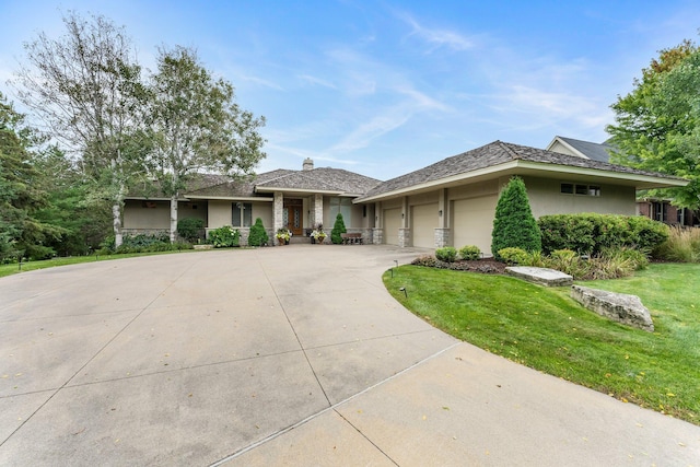 view of front of home with a front yard, an attached garage, stucco siding, and concrete driveway