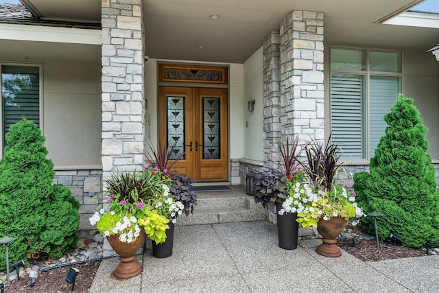 entrance to property featuring french doors and stone siding