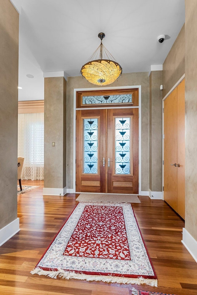 foyer with wood finished floors and baseboards