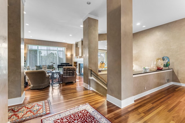interior space with recessed lighting, a fireplace, baseboards, and wood finished floors