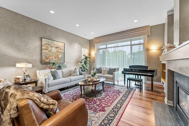 living room with a fireplace with flush hearth, wood finished floors, baseboards, and recessed lighting
