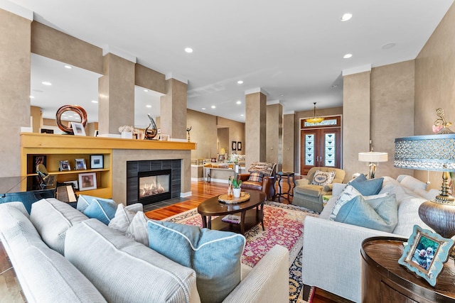 living area with recessed lighting, a fireplace, and wood finished floors