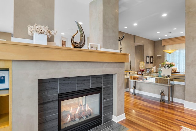 details with recessed lighting, a fireplace, baseboards, and wood finished floors